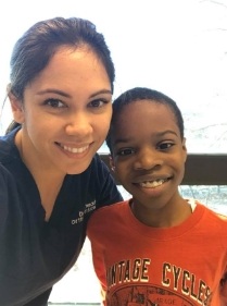 Orthodontic team member and young patient smiling