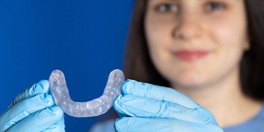 A dentist holding an orthodontic mouthguard