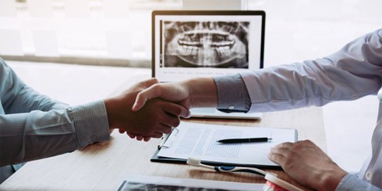 patient and dentist shaking hands    