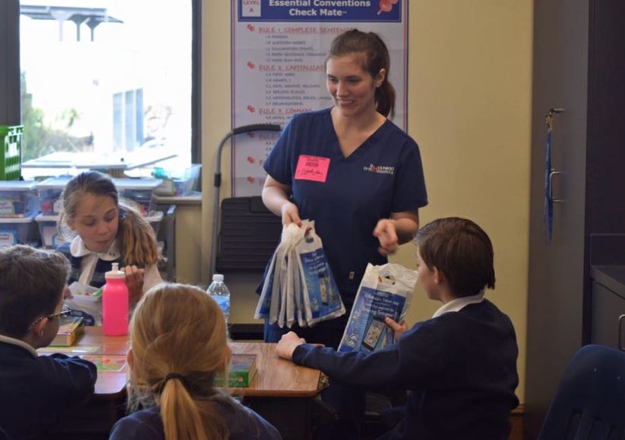 Orthodontic team member at school volunteering with kids