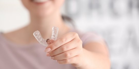 Patient holding up a broken aligner