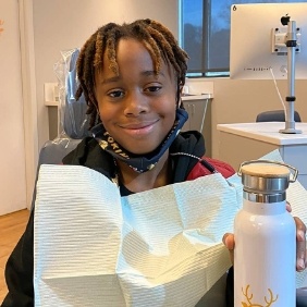 Orthodontic patient holding up a branded water bottle