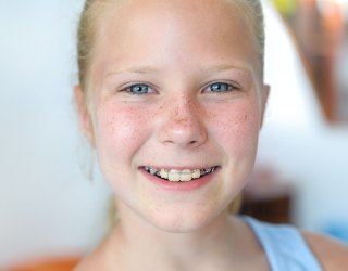 Child with orthodontic appliance smiling