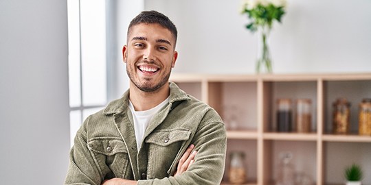 Man smiling while brushing his teeth