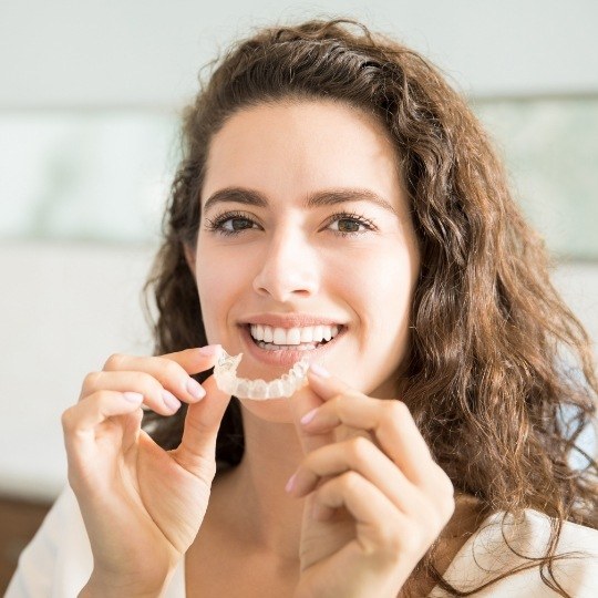 Woman placing her Invisalign tray
