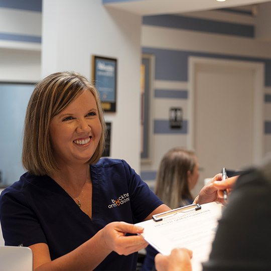 Orthodontic team member accepting orthodontic insurance forms