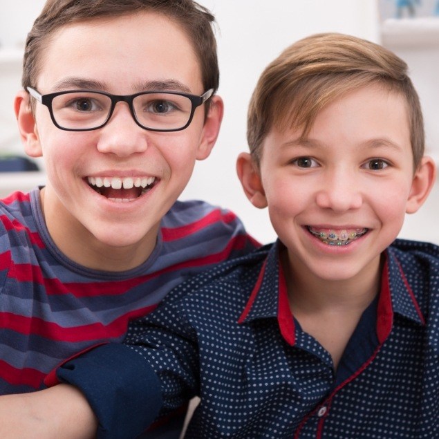 Two preteens smiling during phase one pediatric orthodontics treatment