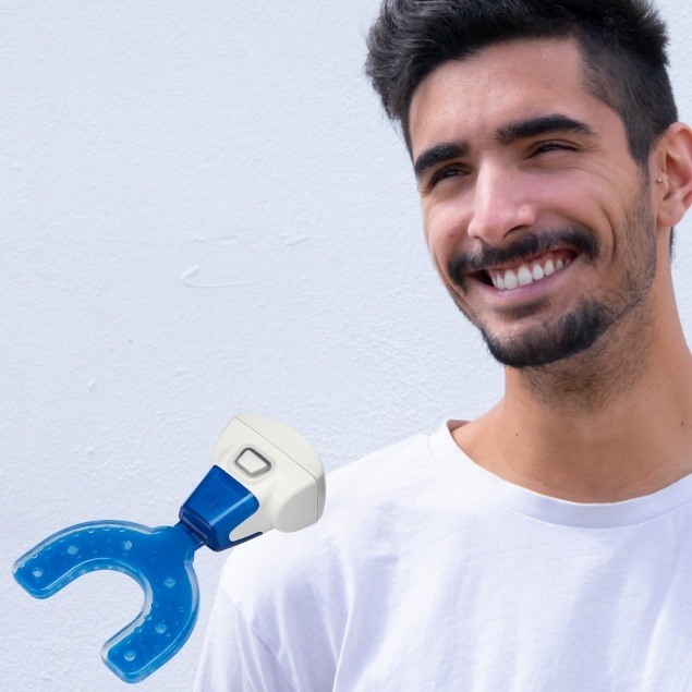 Man smiling with propel accelerated orthodontics hand set