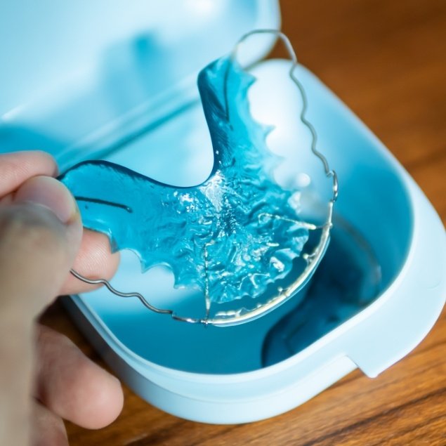 Patient placing a retainer in a carrying case
