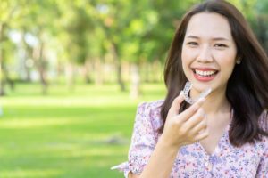 girl holding Invisalign aligner